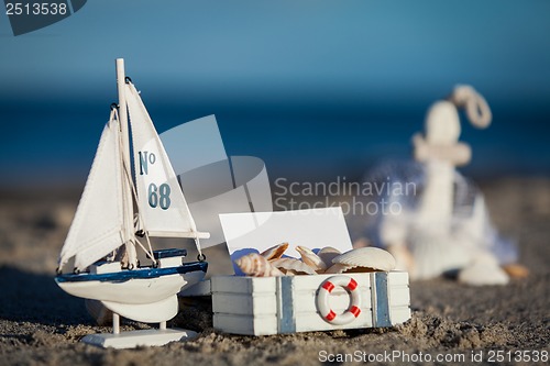 Image of sailing boat and seashell in sand decoration closeup