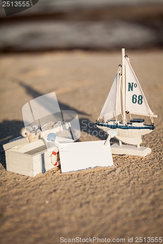 Image of sailing boat and seashell in sand decoration closeup