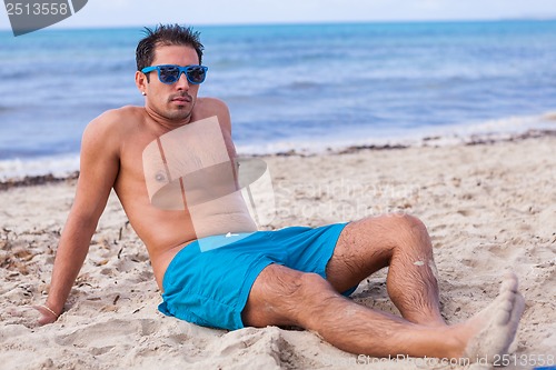 Image of attractive young athletic man on the beach