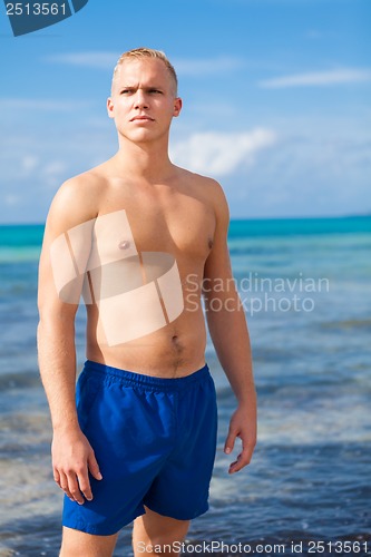 Image of attractive young athletic man on the beach