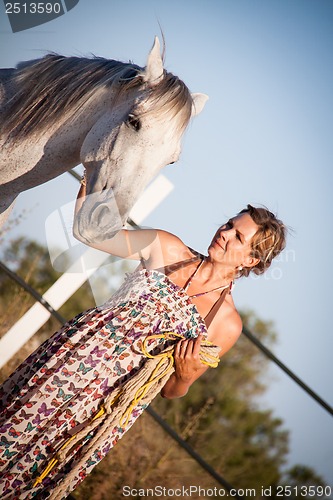 Image of young woman walking a road with horse