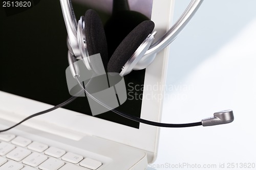 Image of headset keyboard notebook laptop in office on table desk