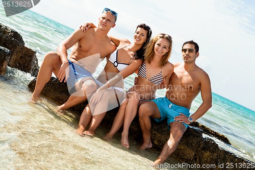 Image of young happy friends havin fun on the beach