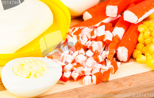 Image of sliced crab sticks,mayonnaise, corn and egg on bamboo cutting board