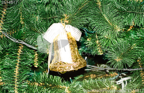 Image of Gold Christmas bell and green spruce branch 