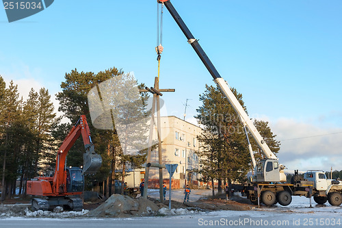 Image of Installing a power pole with the use of special equipment