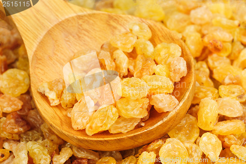 Image of Golden raisins close- up and wooden spoon, food background