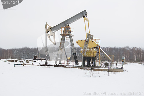 Image of oil pump works   on winter forest  background