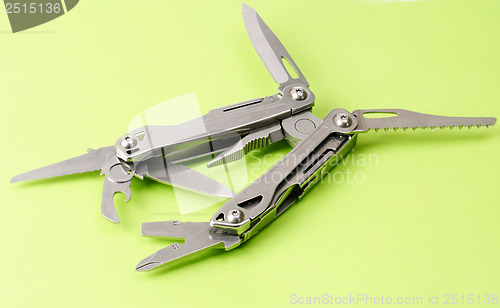 Image of multitool isolated ower green background 