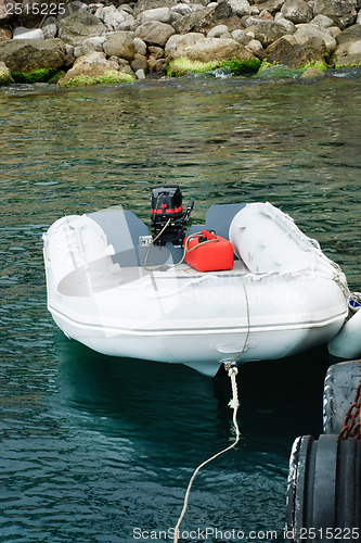 Image of Motor boat is white with a red engine on the dock