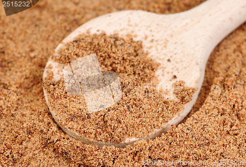 Image of Nutmeg ground (Myristica fragrans) texture and wooden spoon, full frame background. Used as a spice and medicine. 