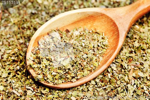 Image of Dried marjoram spice and wood spoon as food background 