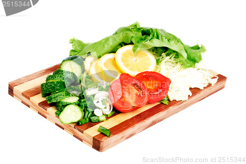 Image of fresh fruits and vegetables on a bamboo cutting board