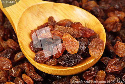 Image of raisins and  wooden  spoon close- up food background 