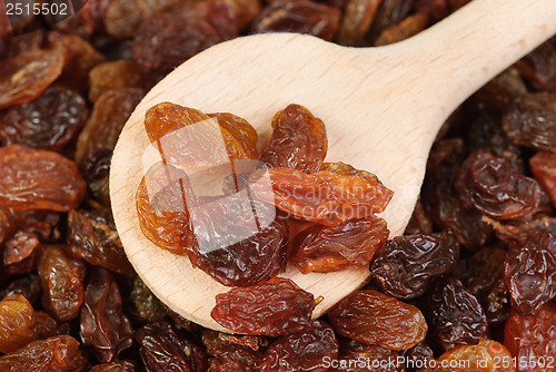 Image of raisins and  wooden  spoon close- up food background 