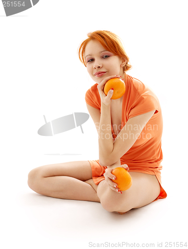 Image of cheerful redhead with two oranges