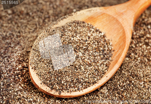 Image of Ground black pepper (Piper nigrum) with wooden spoon 
