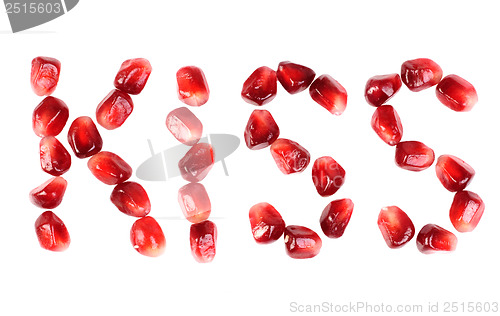 Image of word of kiss  from the seeds of a pomegranate isolated on white 