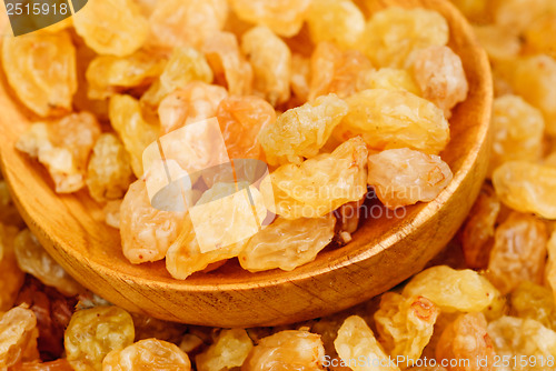 Image of Golden raisins close- up and wooden spoon, food background 