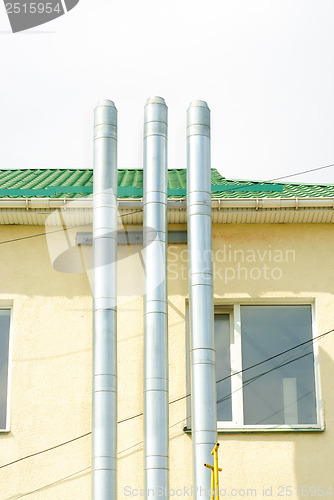 Image of Three chimney smoke on  building background