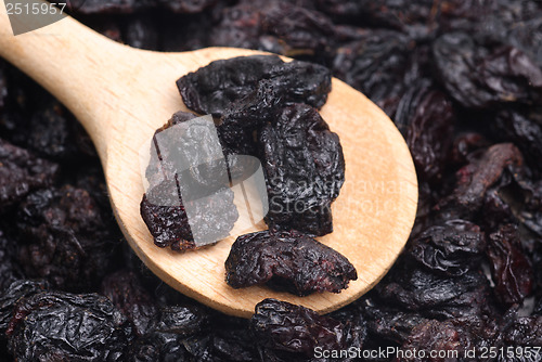 Image of raisins and  wooden  spoon close- up food background 