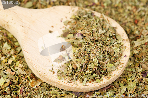Image of Pile of ground dried Basil (Sweet Basil) as background with wooden spoon. Used as a spice in culinary herb all over the world. The plant is also used in medicine. 