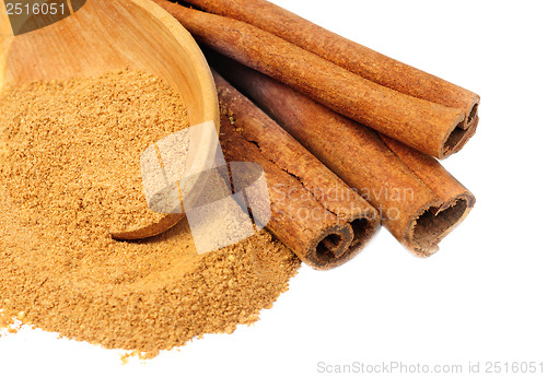 Image of Cinnamon -  sticks and powder  and  wooden spoon  isolated  on  white