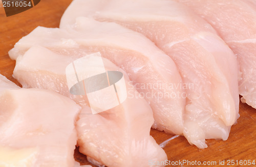 Image of chicken meat sliced   on  cutting  board isolated  on  white  background