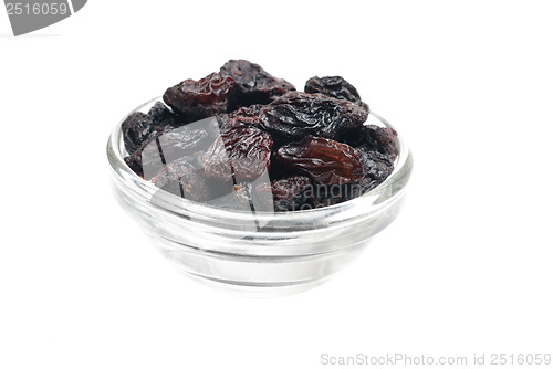 Image of dark  raisins close- up in glass bowl isolated  on  white background