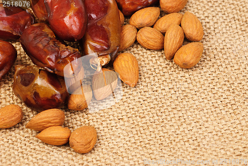 Image of dried dates and almonds on canvas background