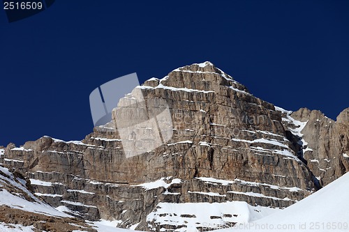 Image of Rocks in snow and blue clear sky