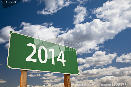 Image of 2014 Green Road Sign Over Clouds