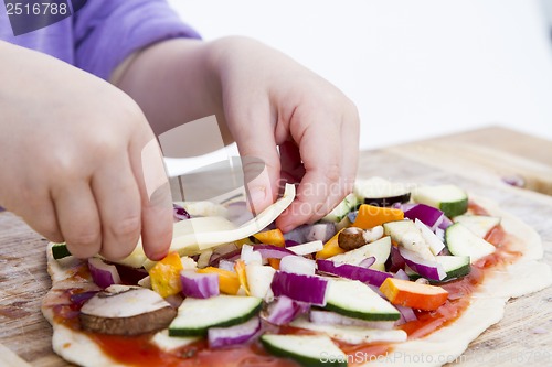 Image of small hands preparing pizza