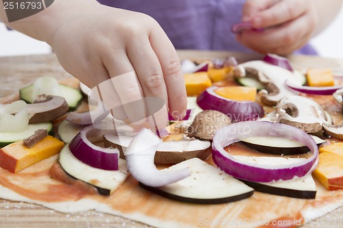 Image of small hands preparing pizza