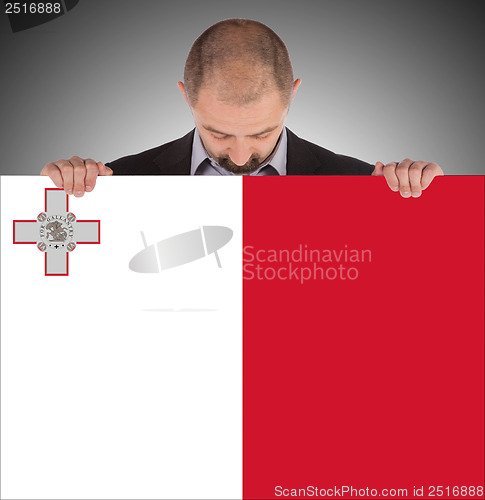 Image of Smiling businessman holding a big card or flag