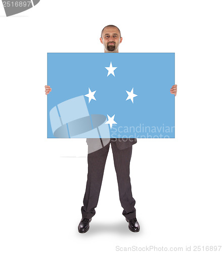 Image of Smiling businessman holding a big card or flag