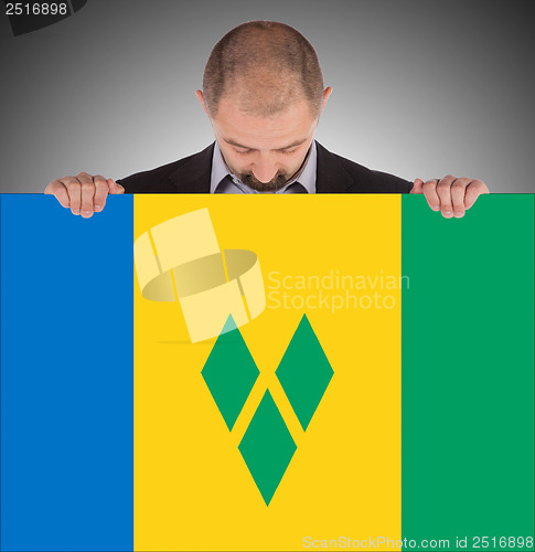 Image of Smiling businessman holding a big card or flag