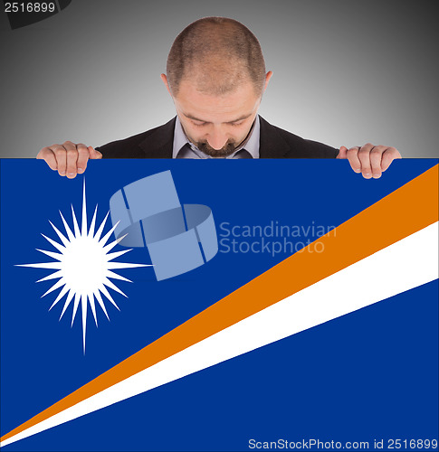 Image of Smiling businessman holding a big card or flag