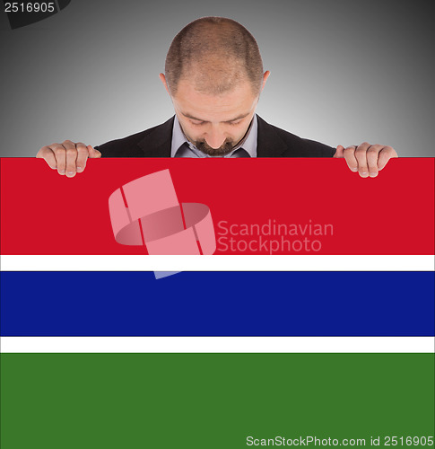 Image of Smiling businessman holding a big card or flag
