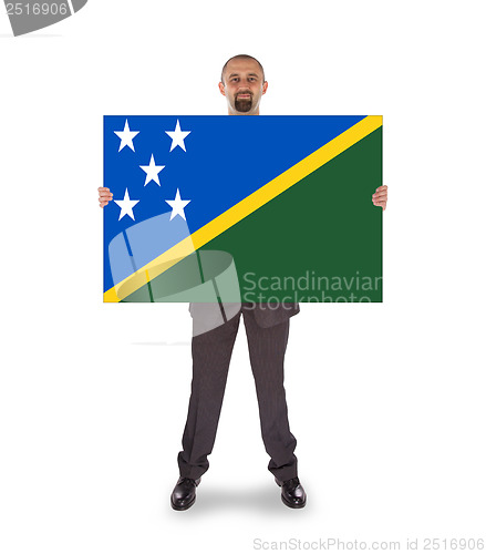 Image of Smiling businessman holding a big card or flag