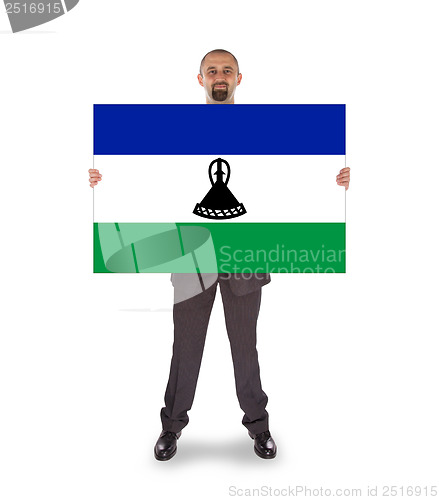 Image of Smiling businessman holding a big card or flag