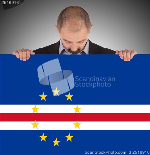Image of Smiling businessman holding a big card or flag