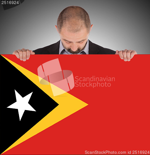 Image of Smiling businessman holding a big card or flag
