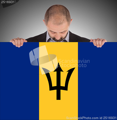 Image of Smiling businessman holding a big card or flag