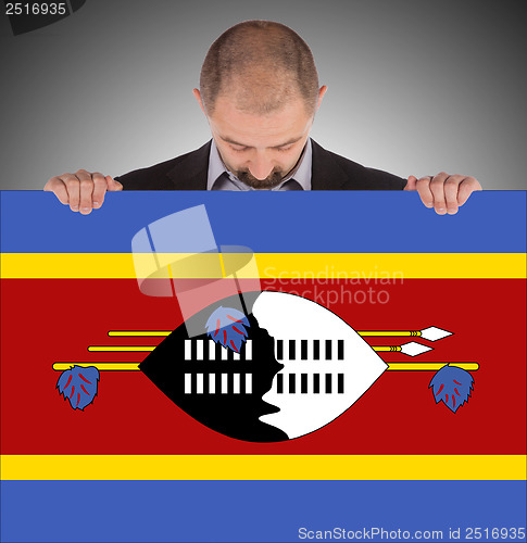 Image of Smiling businessman holding a big card or flag