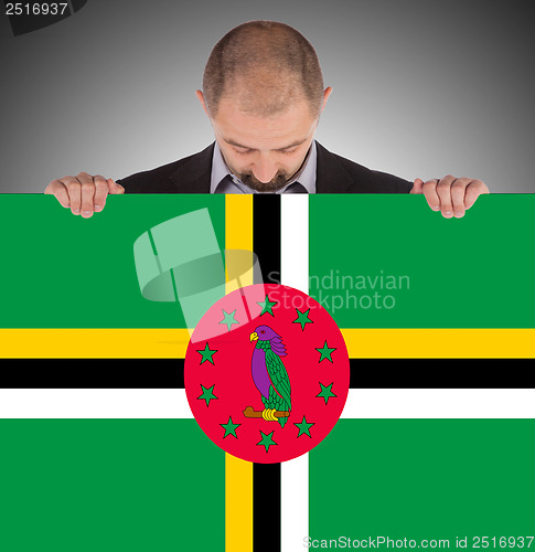 Image of Smiling businessman holding a big card or flag