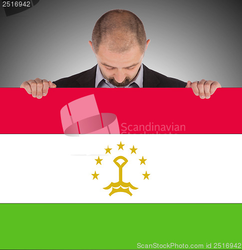 Image of Smiling businessman holding a big card or flag