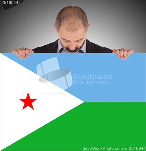 Image of Smiling businessman holding a big card or flag