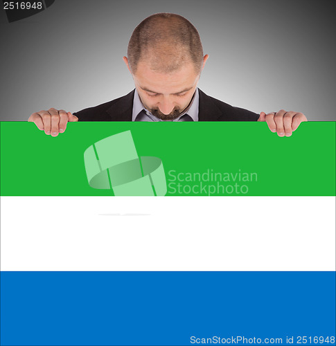 Image of Smiling businessman holding a big card or flag