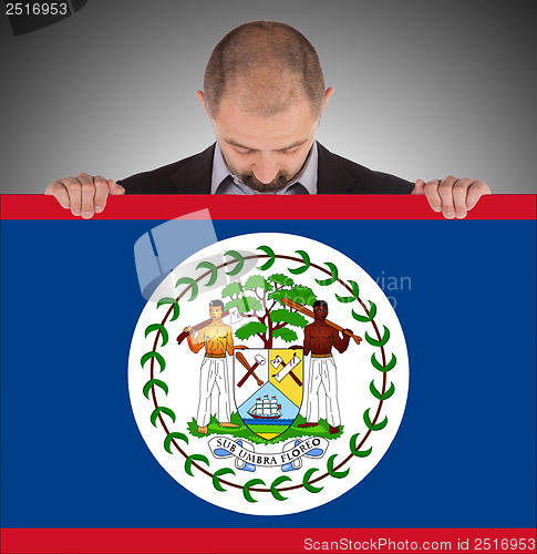 Image of Smiling businessman holding a big card or flag